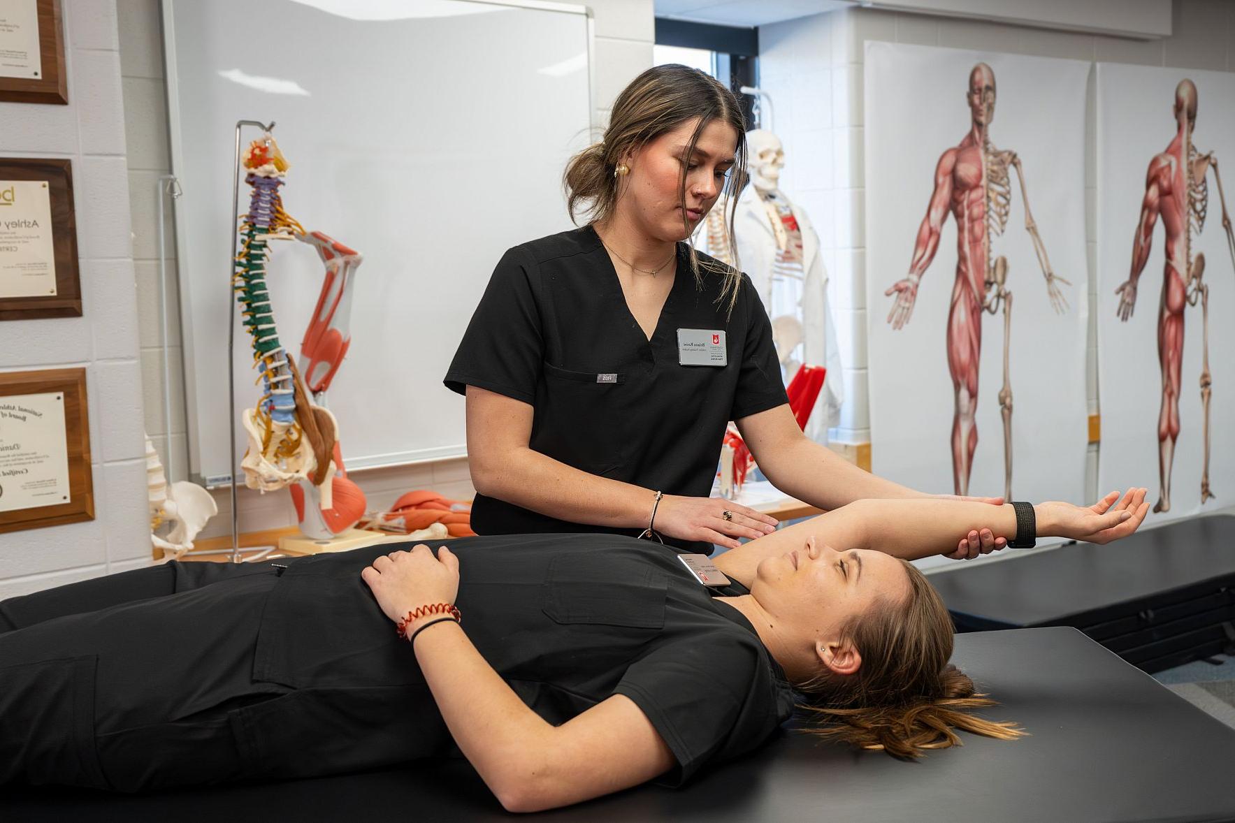 Master of Athletic Training students gather for a demonstration during an athletic training class.